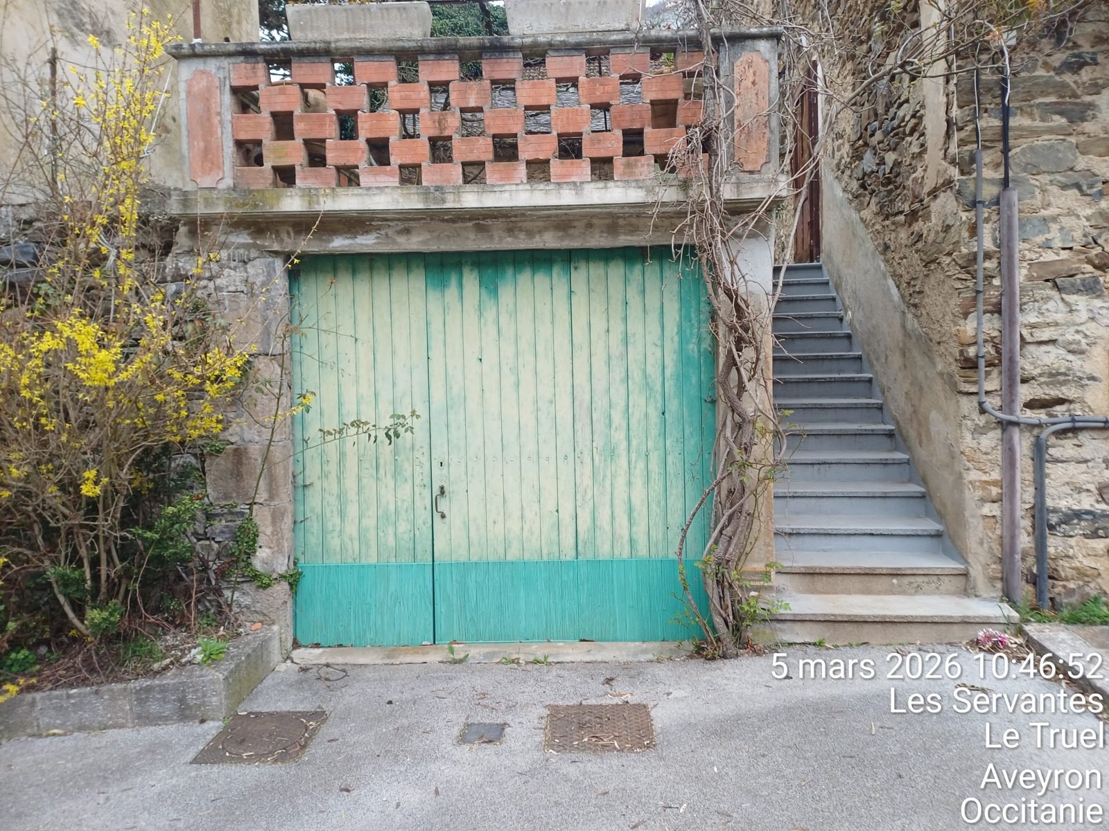 Porte de garage en bois écaillée, peinture turquoise abîmée